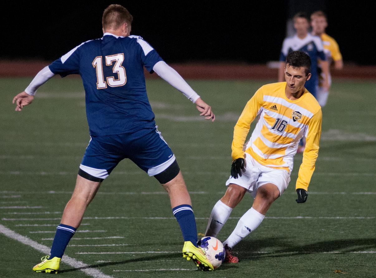 Jakub Rys, who had one of the Titans' 17 shots on goal, battles Logan Massey of Marian University for the ball.