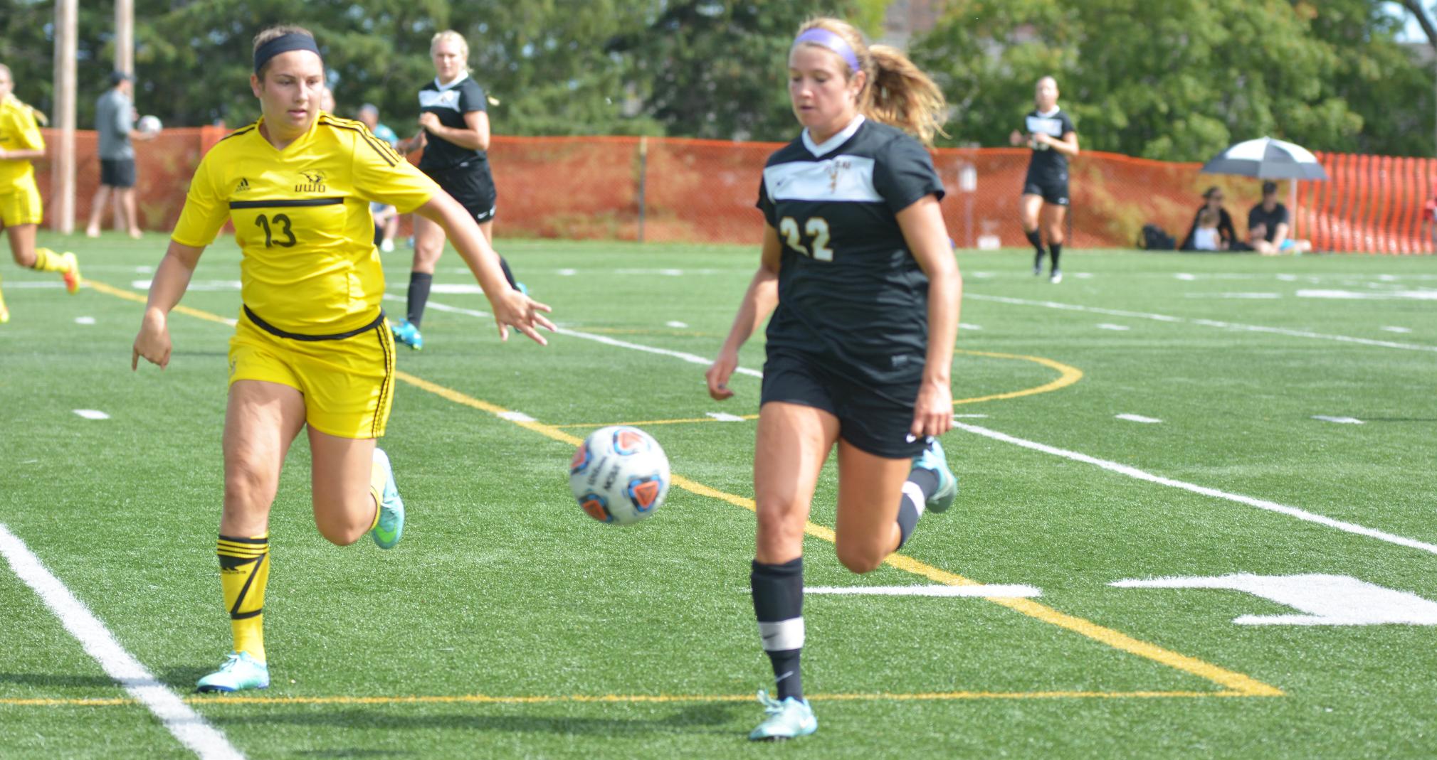 Ashley Markowiak battles St. Olaf College's Hannah Stoker for the loose ball.