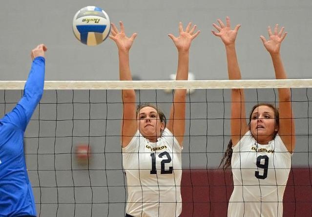 Morgan Cizauskas (left) and Brooke Brinkman combine for a block against Luther College.